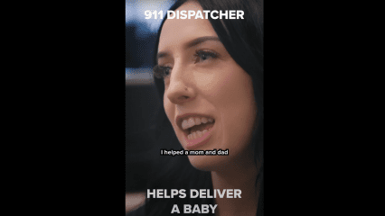 A close-up of a woman with long dark hair and a nose piercing, speaking on camera in an indoor setting. She is smiling slightly while talking. On-screen subtitle text reads, “I helped a mom and dad.” Bold white text at the top reads: “911 DISPATCHER,” and at the bottom: “HELPS DELIVER A BABY,” highlighting the dispatcher’s role in assisting with an emergency childbirth over the phone.